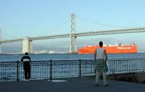 Often overlooked in San Francisco, is the beauty of the Bay Bridge. Here you can only see part of it, its steel-painted
structure reflecting the low, slanting, evening sun. That's me on the right, staring out at a large container ship
passing under the bridge on its way out from the Port of Oakland.